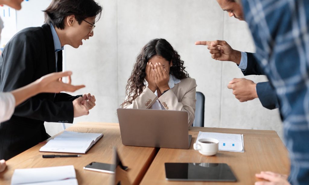 chica siendo acosada laboralmente por el resto de compañeros