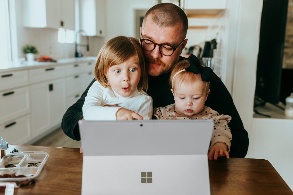 Padre con dos hijos teletrabajando